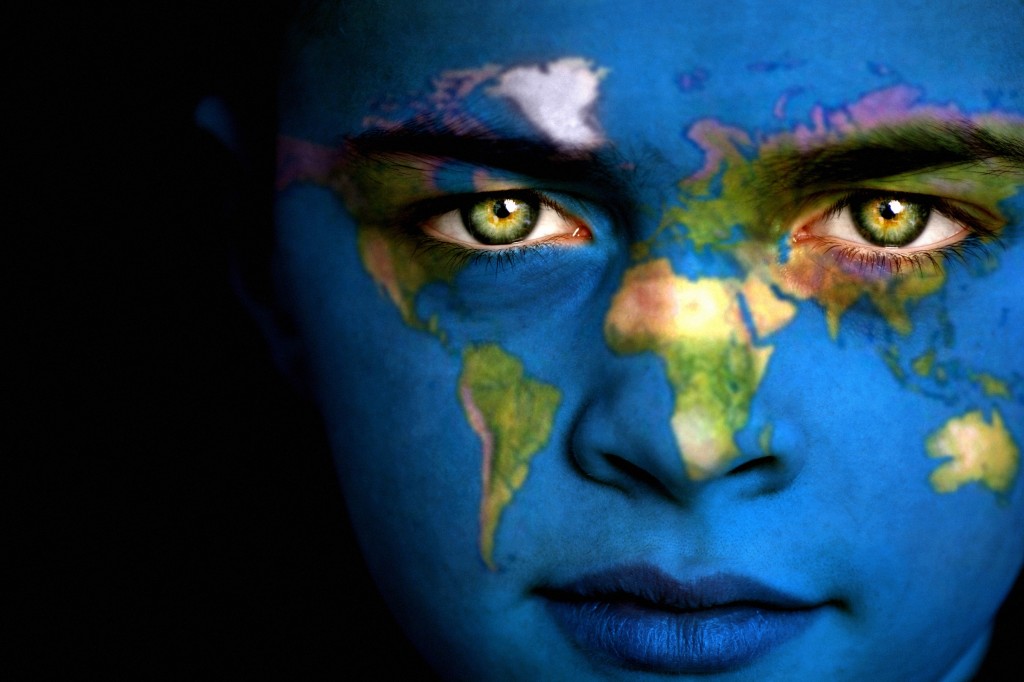 Portrait of a boy with the map of the world painted on his face.