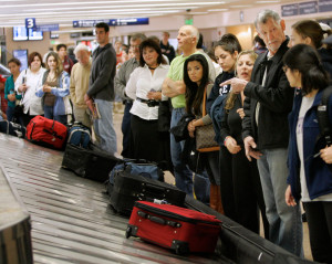 Image: Travelers line up to get their luggage