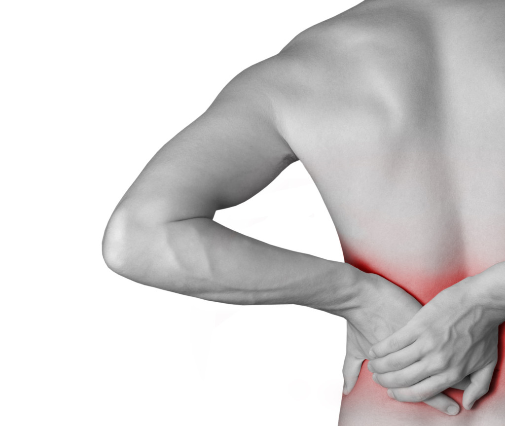 young male holding his back in pain