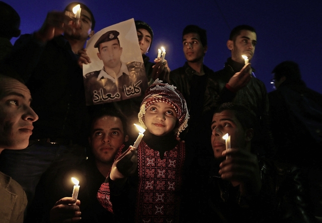 Jordanians hold up a poster of pilot Kasaesbeh, who is being held captive by Islamic State, during a candlelit vigil in a show of solidarity with Japan, in Amman