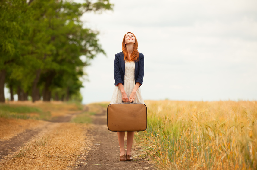 Redhead girl with suitcase at outdoor.
