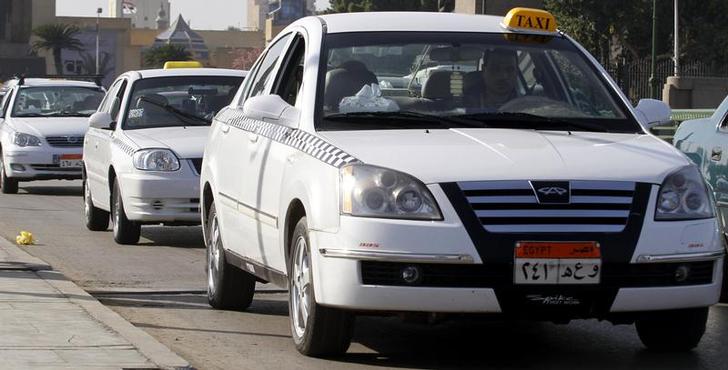 New white taxis are seen on a road in downtown Cairo, December 16, 2010. Cairo's increasingly new fleet of taxis replace rickety old ones, part of a programme of renewal that is also helping car producers and companies in Egypt, and changing the face of Cairo's streets. Picture taken December 16, 2010. REUTERS/Mohamed Abd El-Ghany (EGYPT - Tags: ENVIRONMENT TRANSPORT)