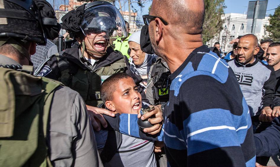 (Photo Credit: Human Rights Watch/ Majd Gaith) Israeli border police arresting Ahmad Abu Sbitan, 11, in front of his school in East Jerusalem. The police accused him of throwing a stone at them.