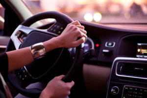 Driving a car at night - pretty, young woman driving her modern car at night in a city (shallow DOF; color toned image)