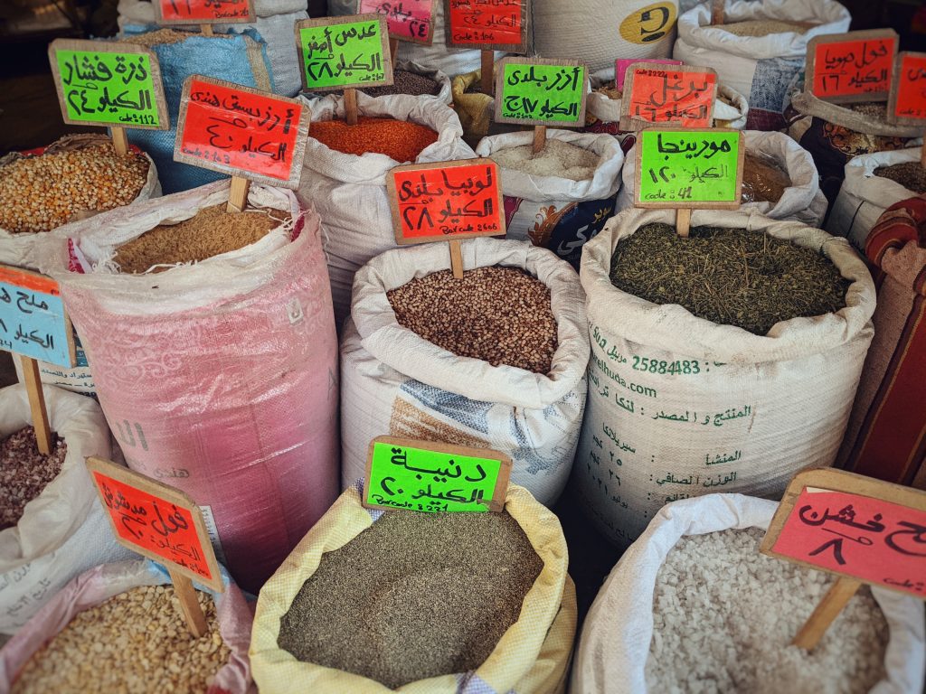 Comparison of a traditional attar selling dried goods out of sacks and an up-market supermarket using plastic bags.
